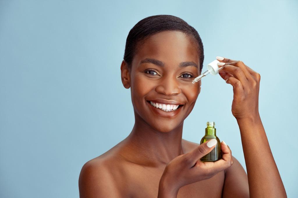 foto mujer aplicandose serum en el rostro
